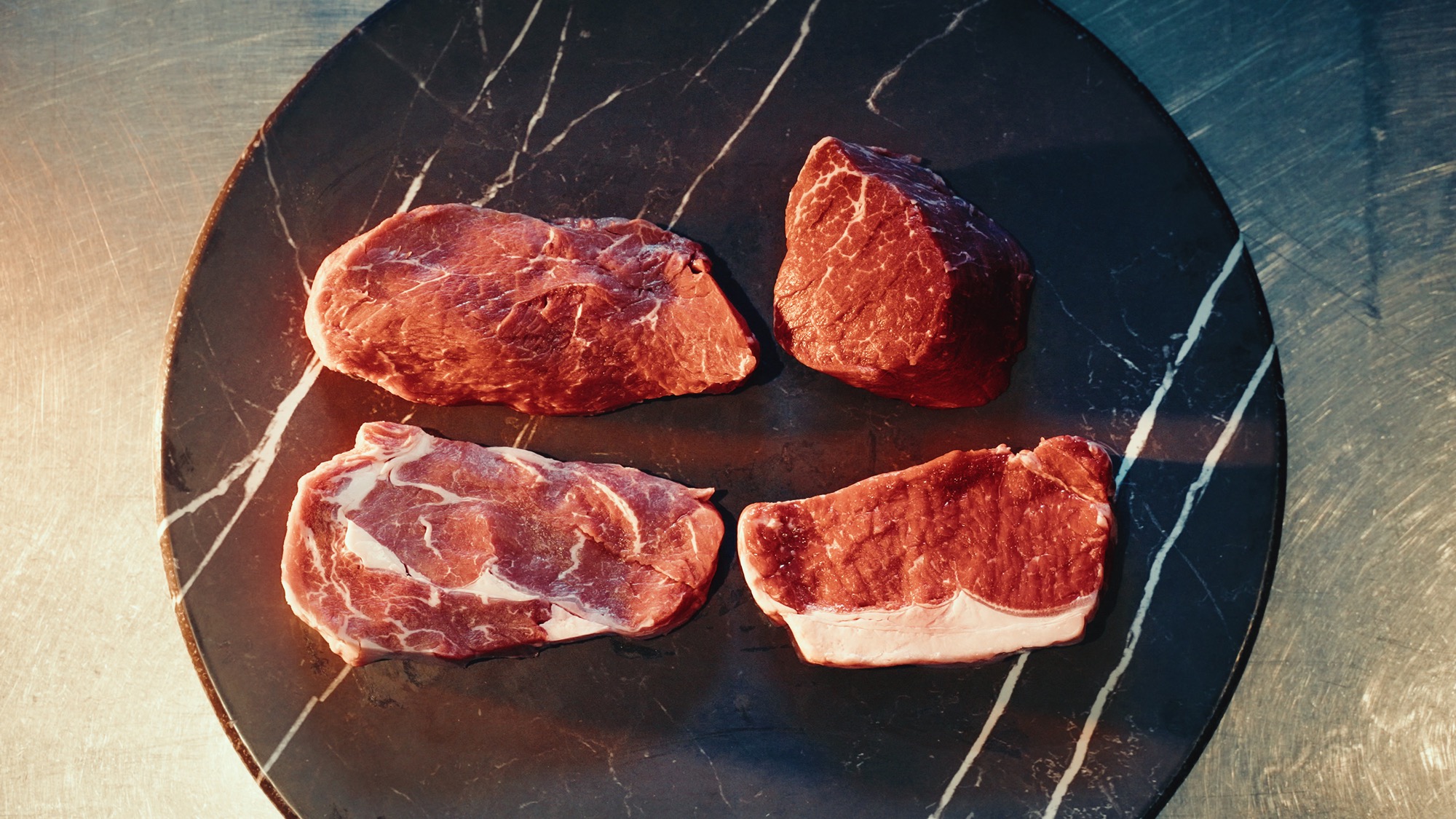 Premium steak cuts on marble surface